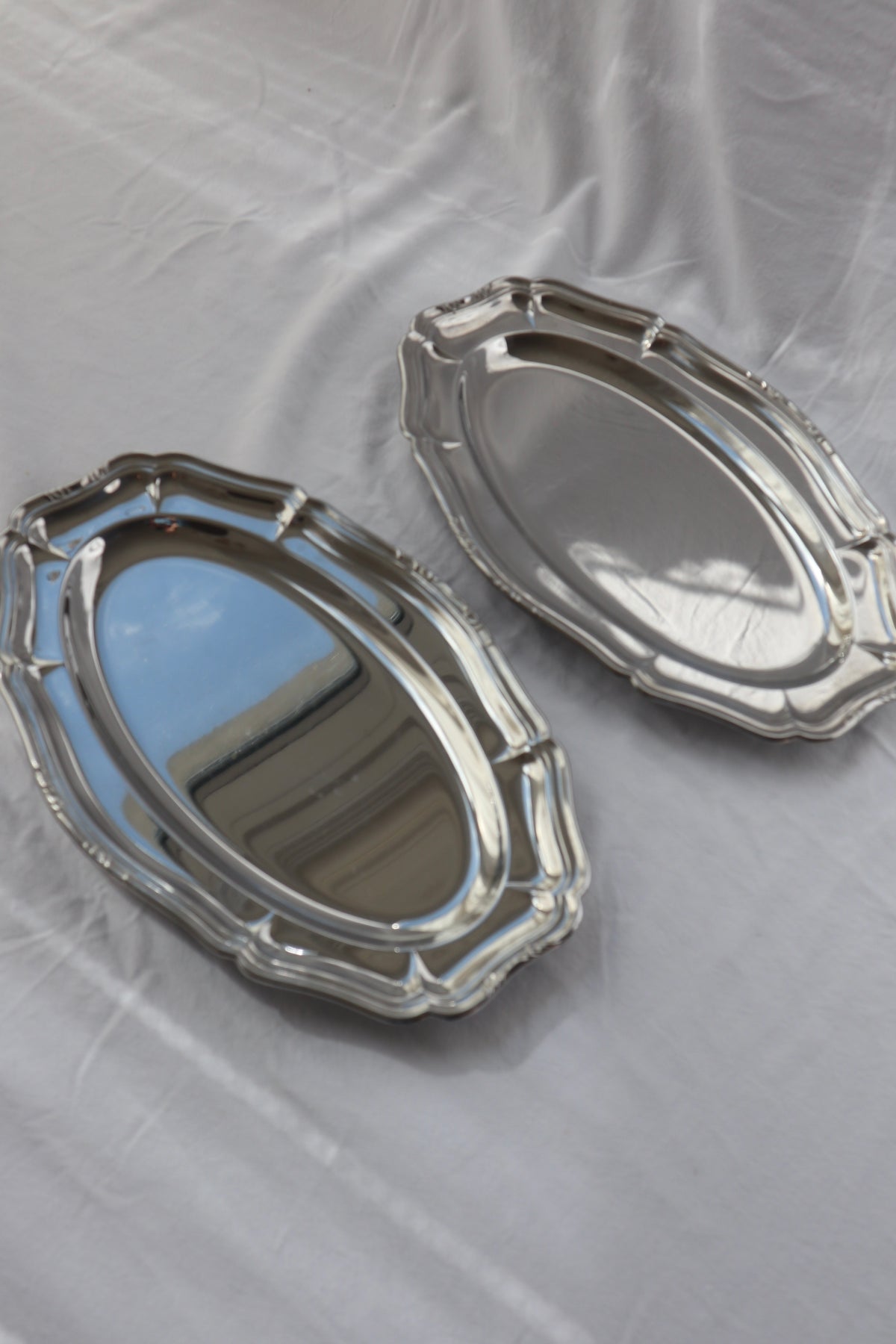 Pair of inox hosting platters with decorative edges
