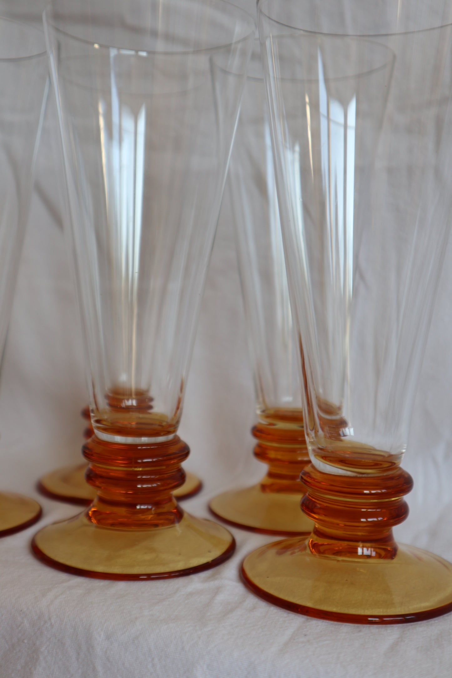 Set of 5 amber glass bobbin-stem mid century flutes
