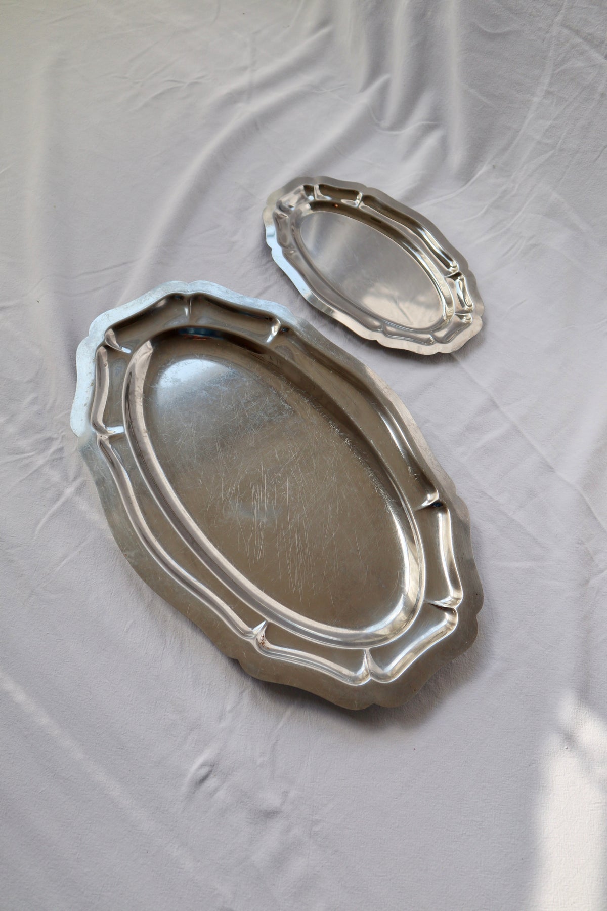 Set of 2 stainless steel hosting platters with scalloped edges