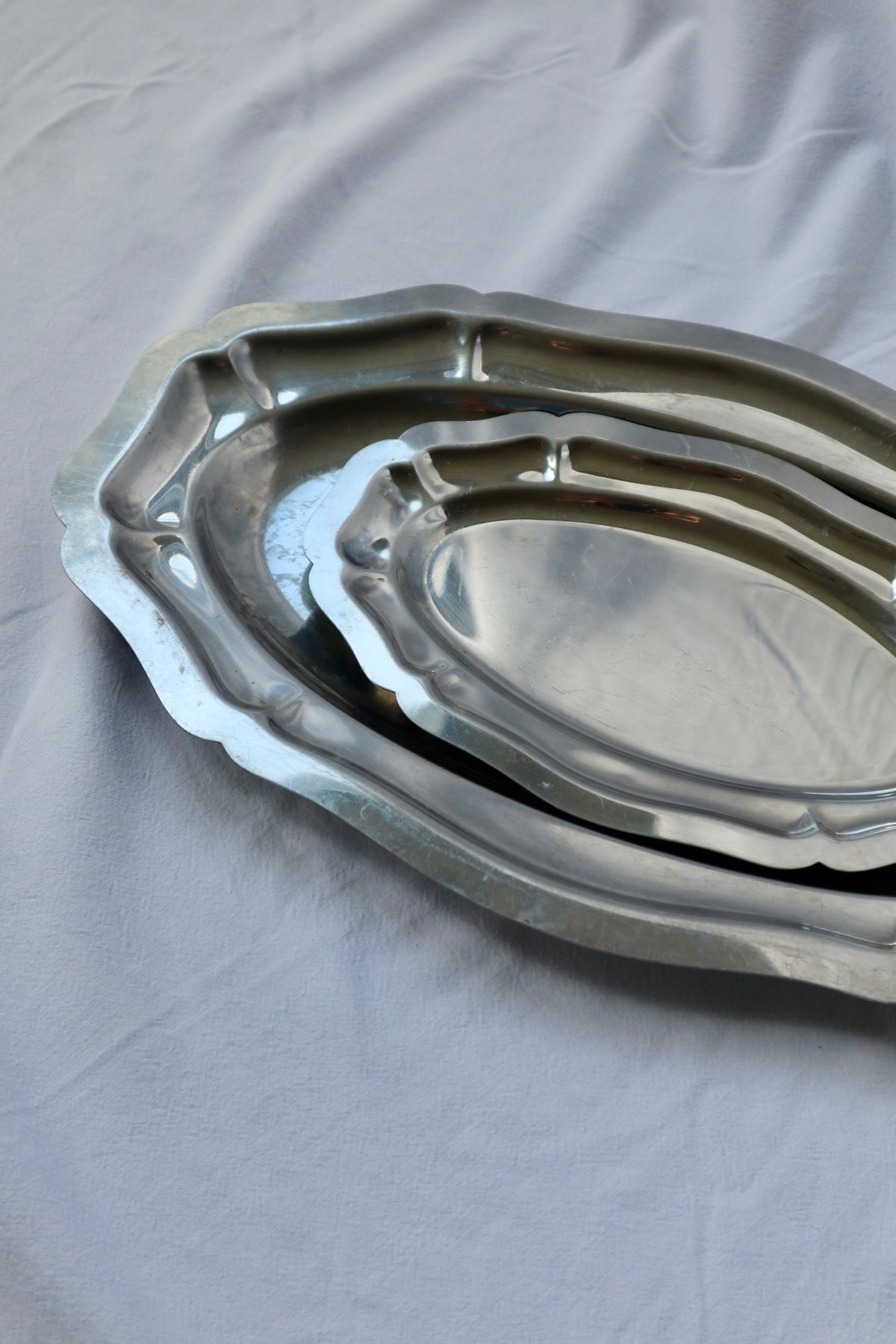 Set of 2 stainless steel hosting platters with scalloped edges