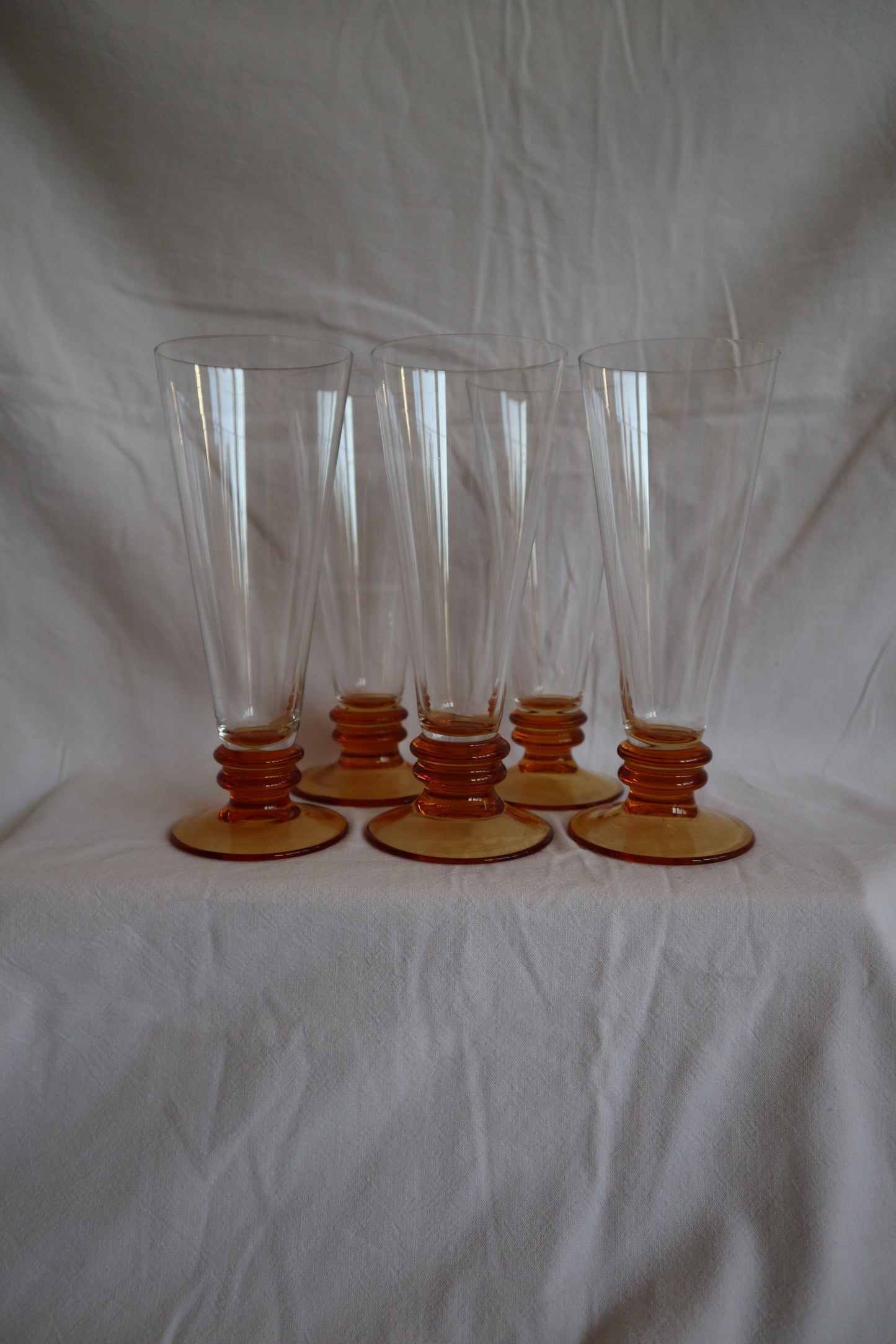 Set of 5 amber glass bobbin-stem mid century flutes